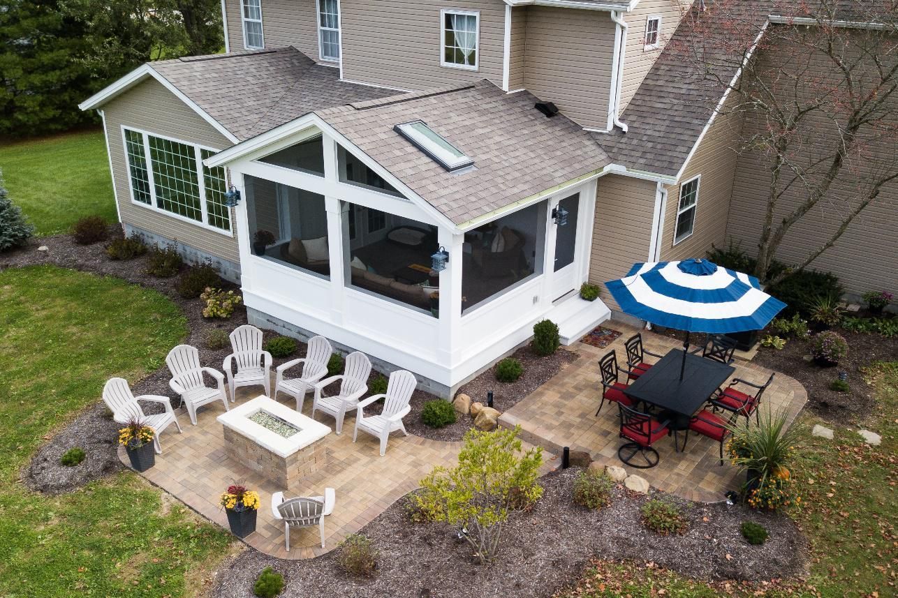 An aerial view of a house with a screened in porch and patio furniture.