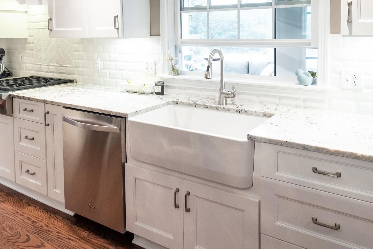 A kitchen with white cabinets and a stainless steel dishwasher.