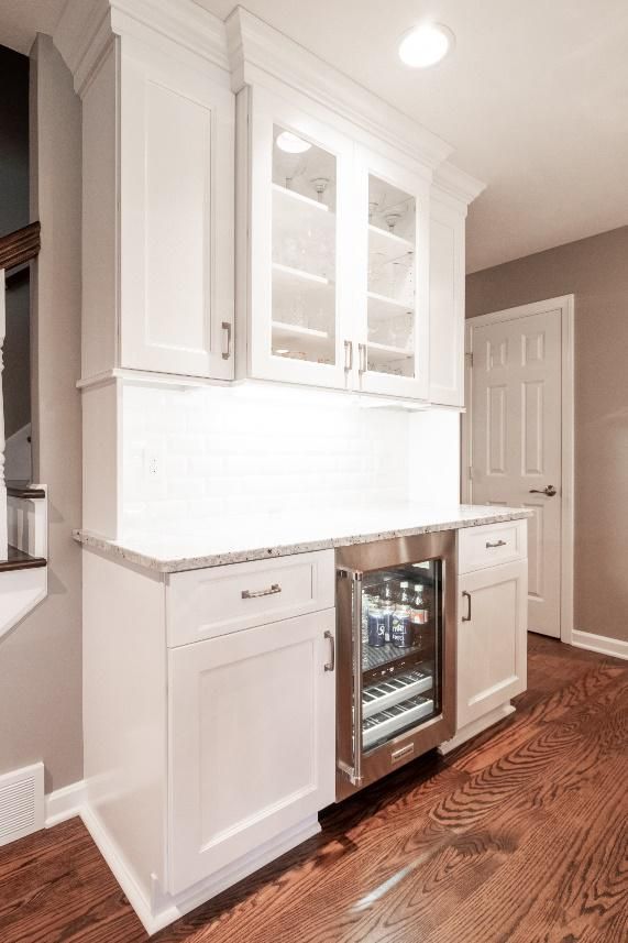 A kitchen with white cabinets and a stainless steel refrigerator.