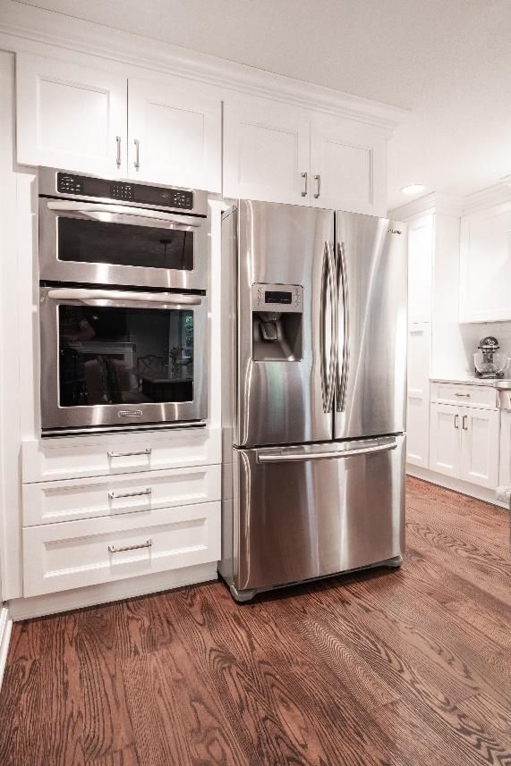 A kitchen with stainless steel appliances and white cabinets.