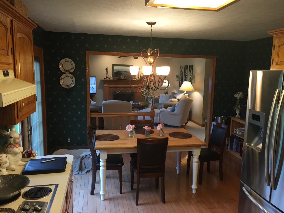 A kitchen with a table and chairs and a refrigerator
