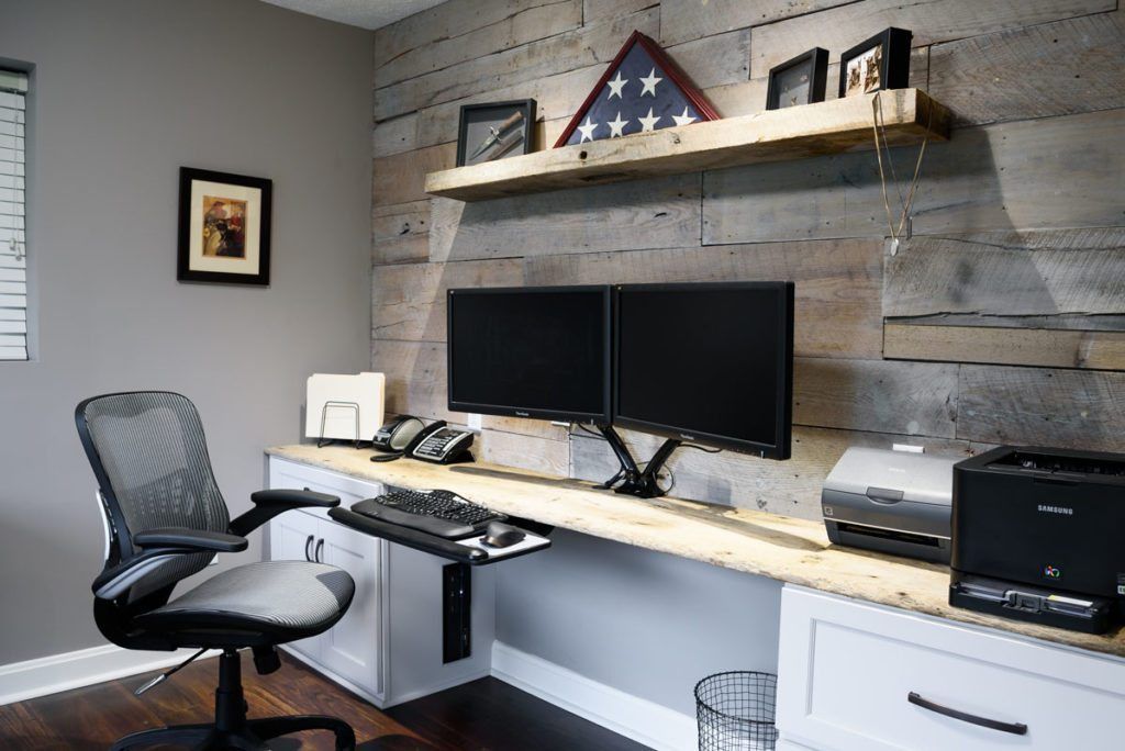 A home office with two computer monitors and a printer.