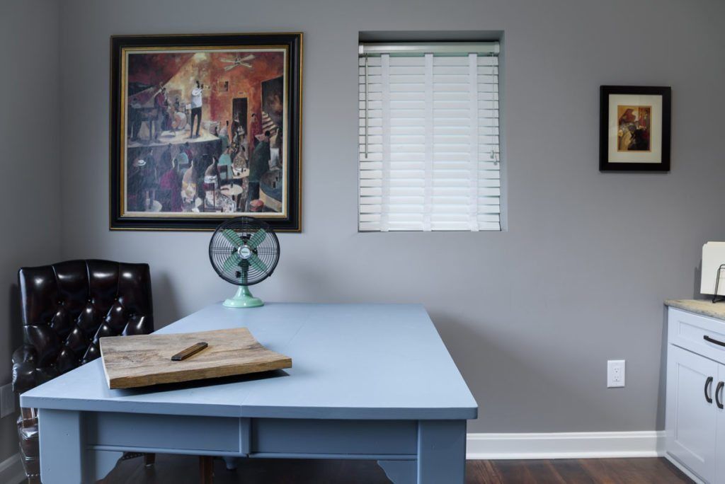 A room with a table and chairs and a fan