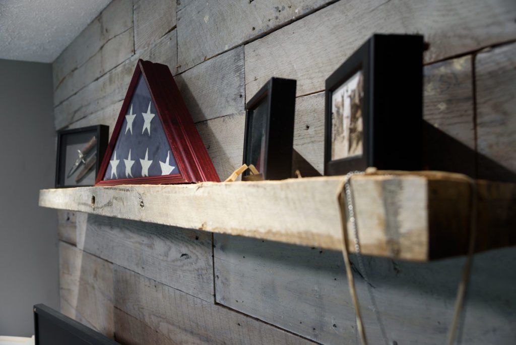 A wooden shelf with pictures and a flag on it.