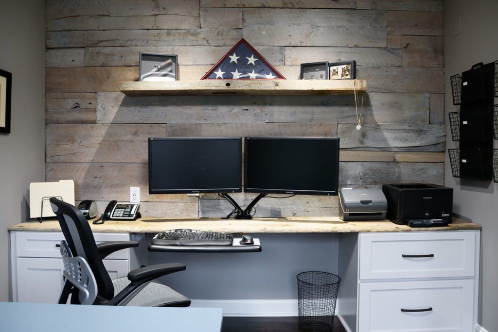 A desk with two monitors and a printer on it