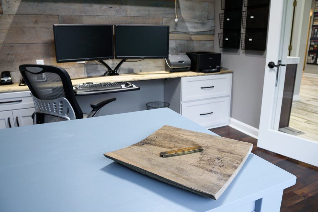 A desk with two monitors and a chair in a home office