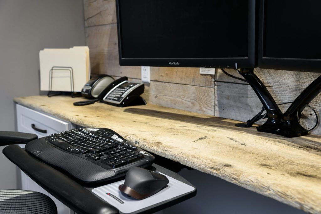 A desk with a keyboard , mouse , and two monitors.