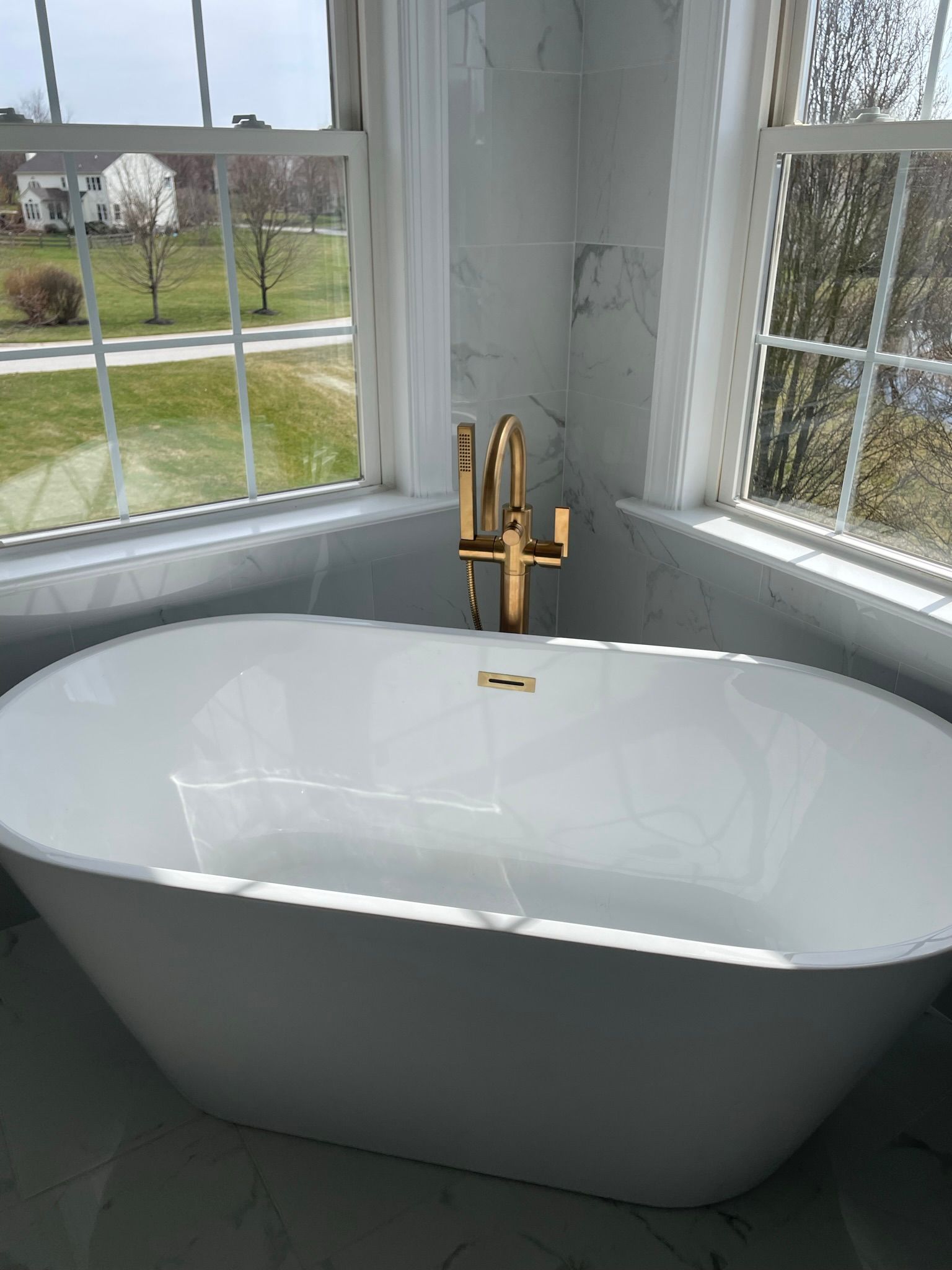 An air conditioner is sitting in the backyard of a brick house.