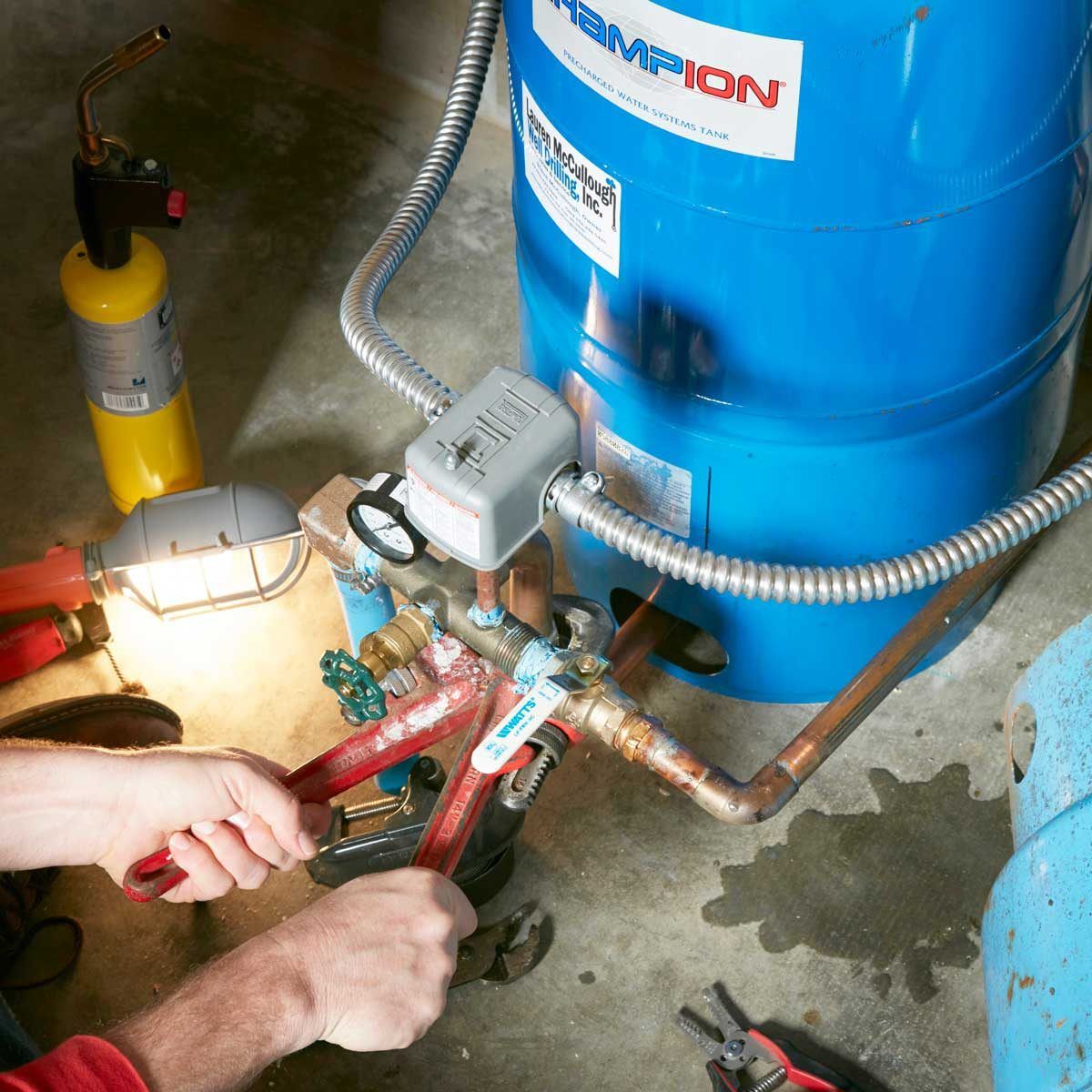 A man is working on a water heater that says champion on it