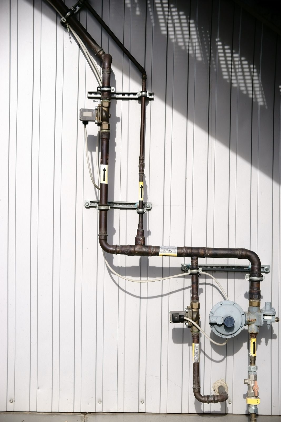 A wall with a bunch of pipes attached to it