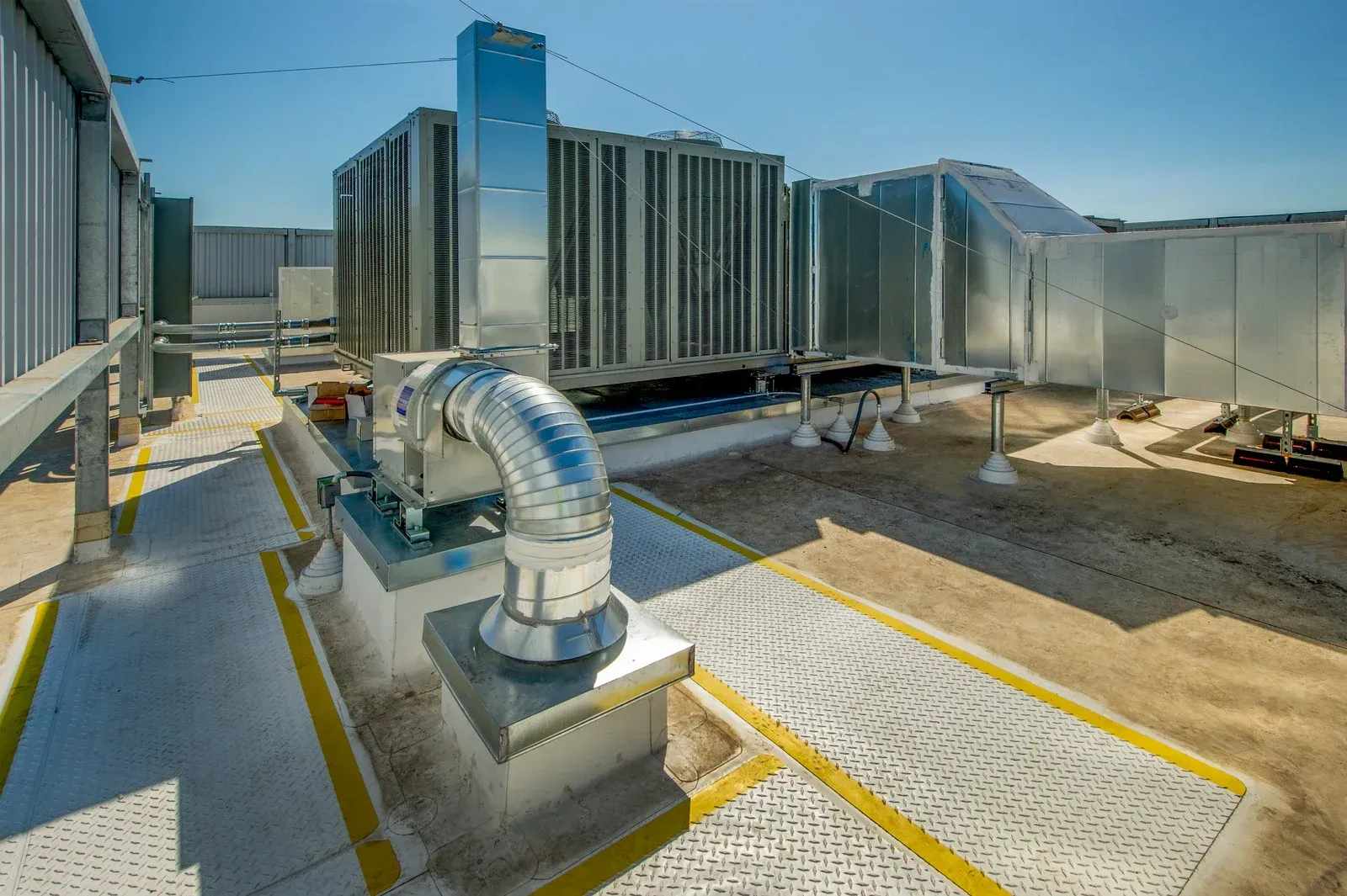 A large ventilation system is sitting on top of a building.