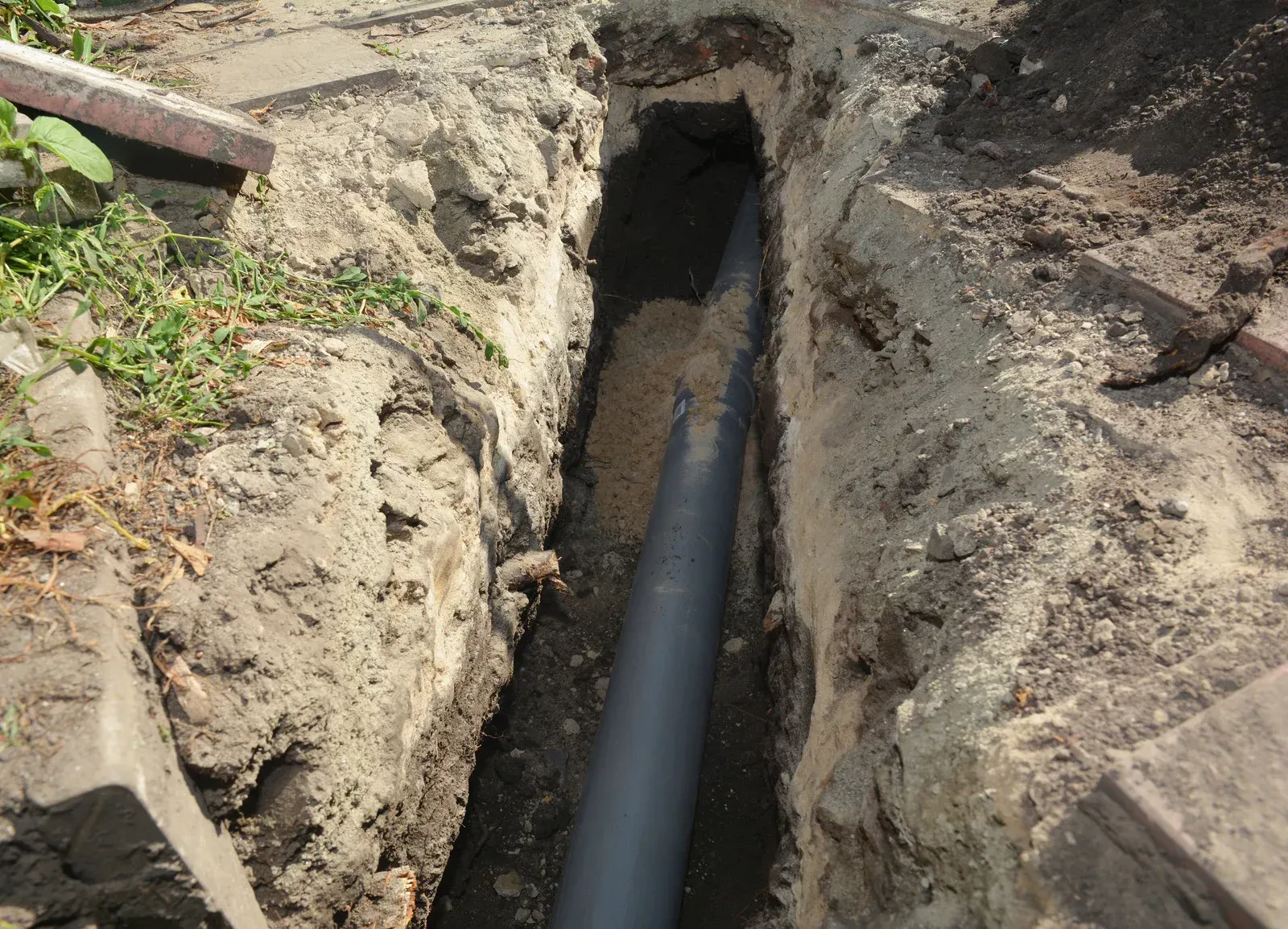 A pipe is going through a hole in the ground