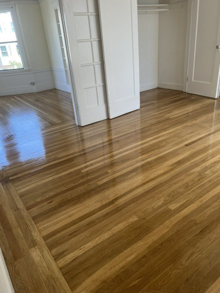 A bedroom with hardwood floors and sliding doors.