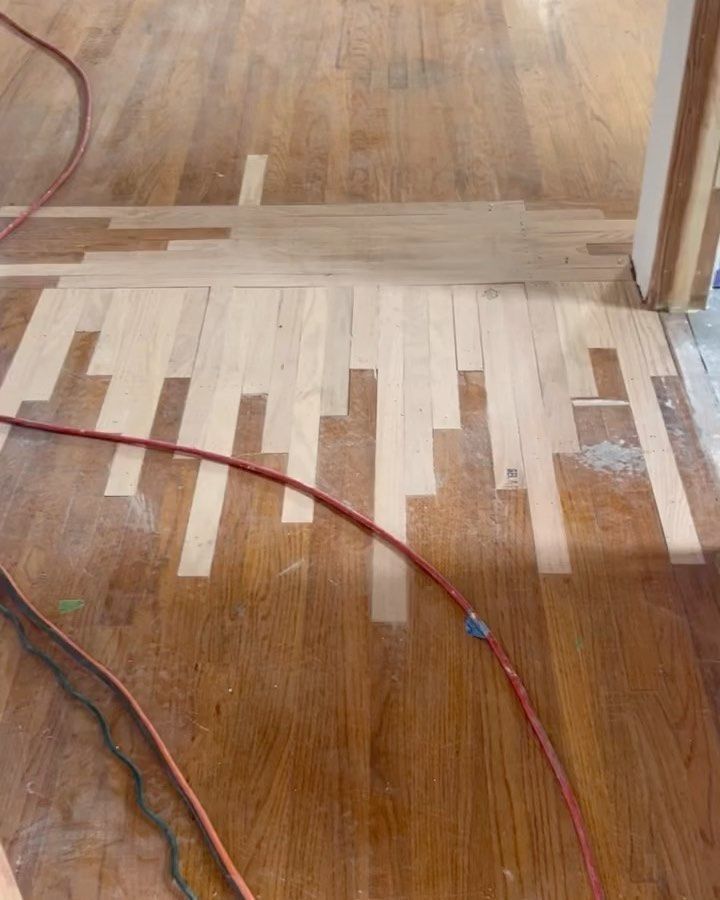 A wooden floor with a red cord laying on it.