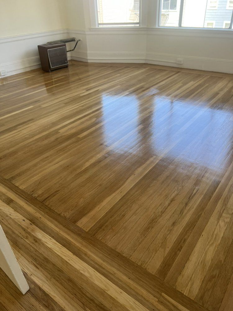 A living room with a wooden floor and a window.