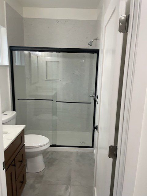 A bathroom with a toilet a sink and a shower