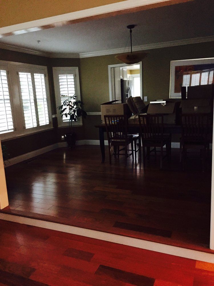 A living room with hardwood floors and a table and chairs