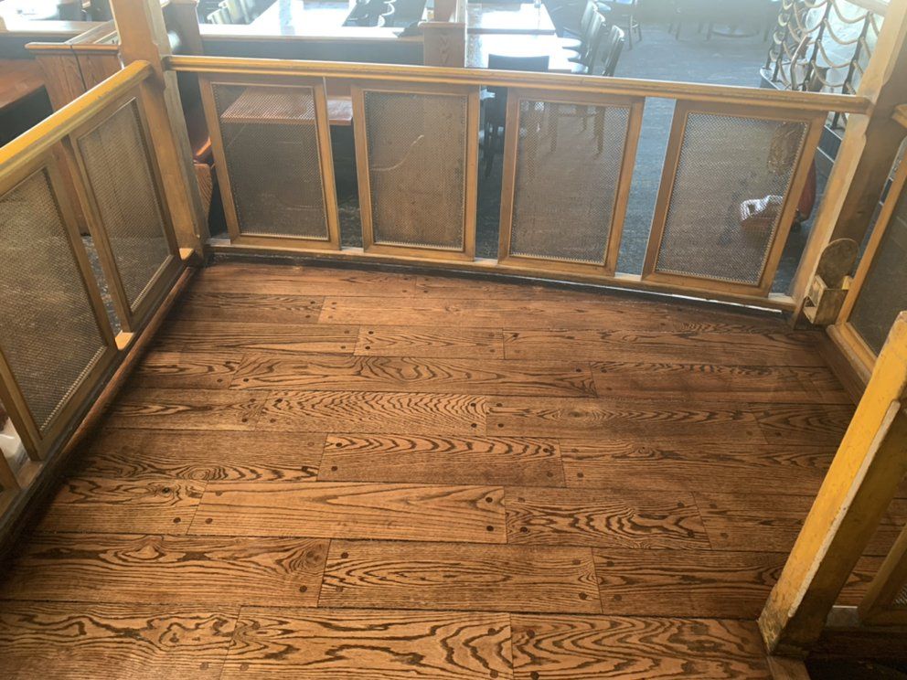 A wooden floor with a yellow railing in a room.