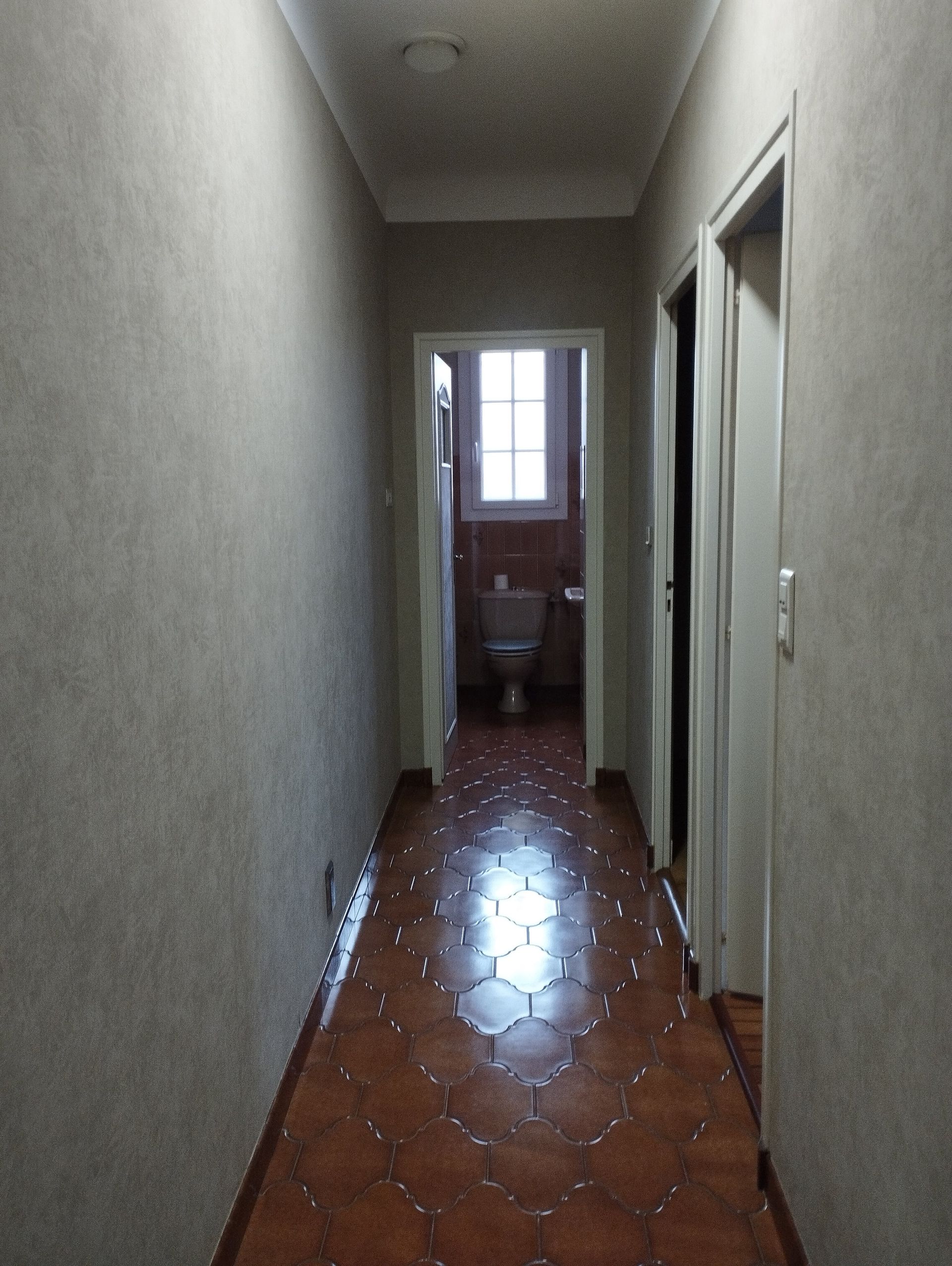 Un long couloir sombre relie les chambres