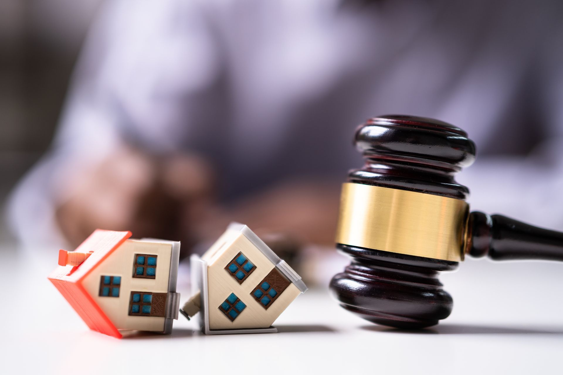A judge 's gavel is sitting on a table next to two small houses.