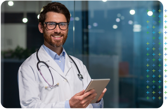 a primary care doctor with a stethoscope around his neck is holding a tablet .