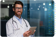 a primary care doctor with a stethoscope around his neck is holding a tablet .