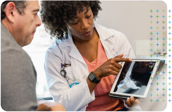 an Orthopaedic doctor is showing a patient an x-ray on a tablet .