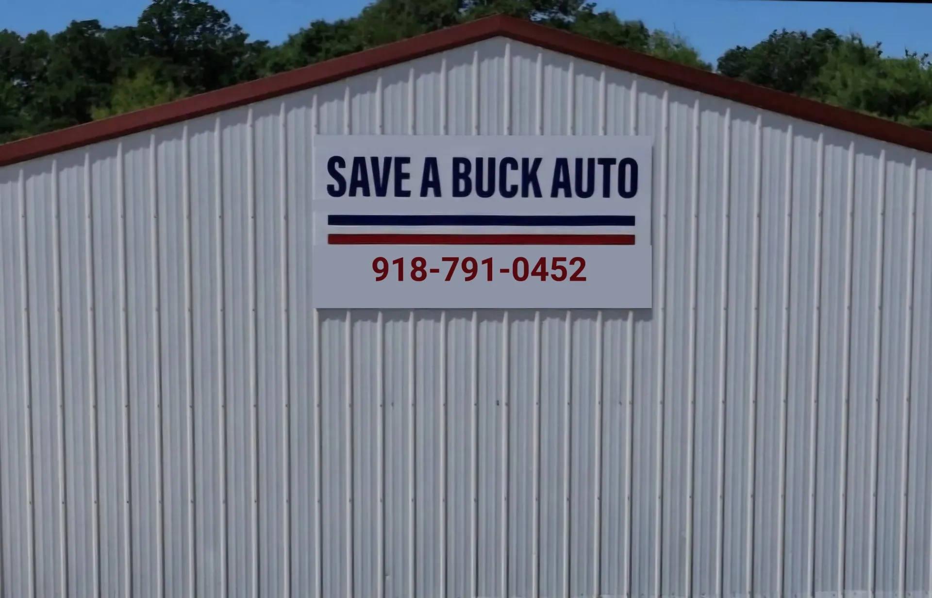 A white metal building with a sign that reads 