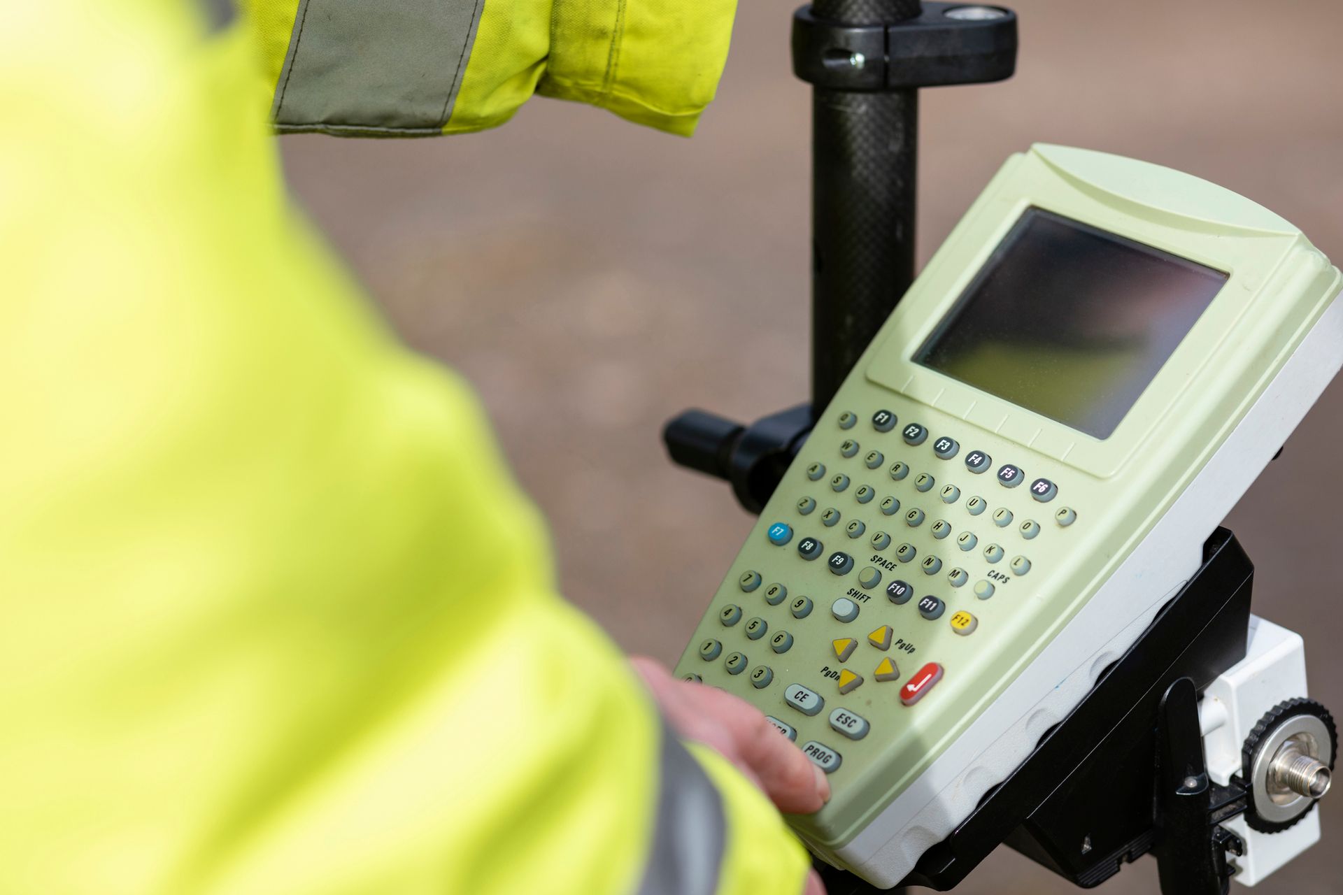 A person in a yellow jacket is holding a remote control