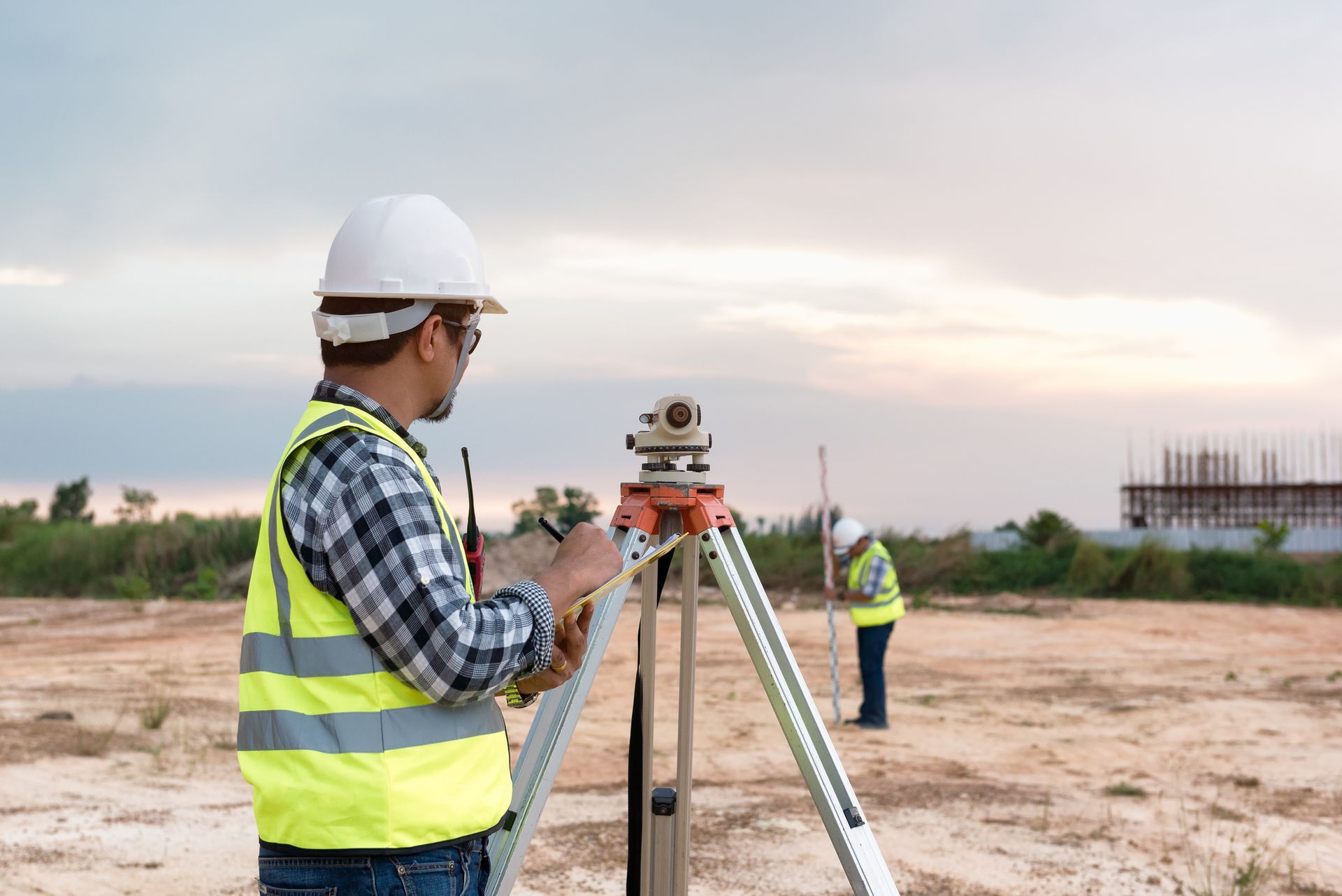 A man is working on a tripod in a field.