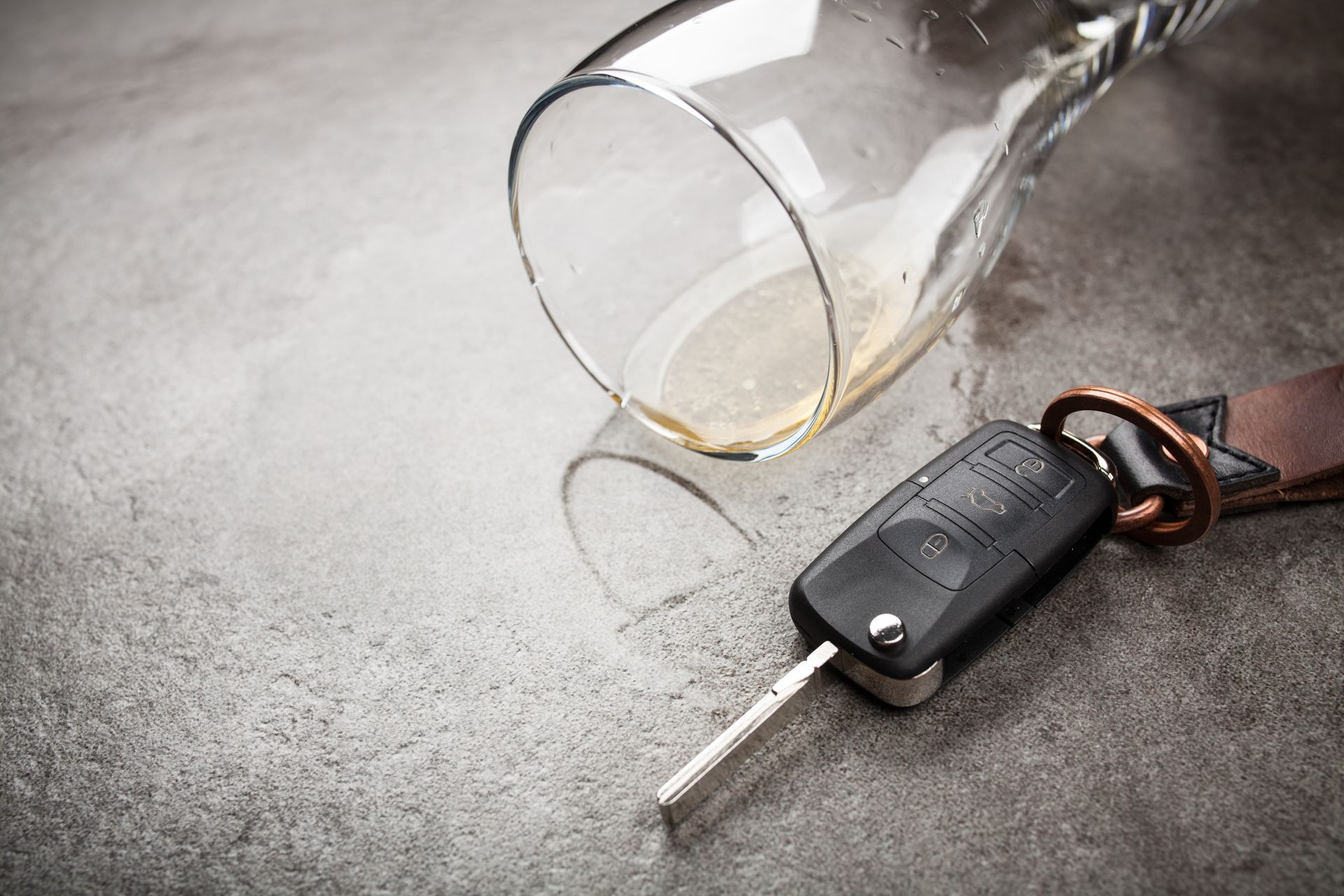 An empty glass and car key symbolizing DUI consequences.