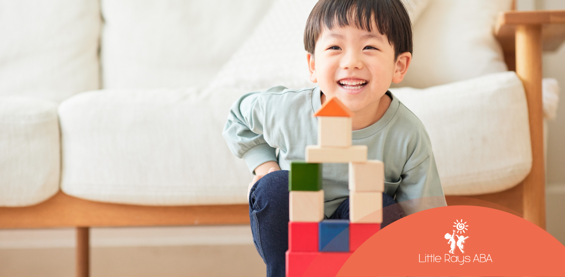 A young boy is sitting on the floor playing with wooden blocks.