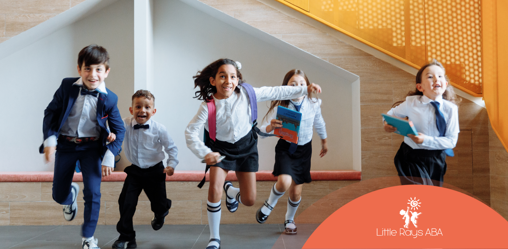 A group of children in school uniforms are running down a hallway.