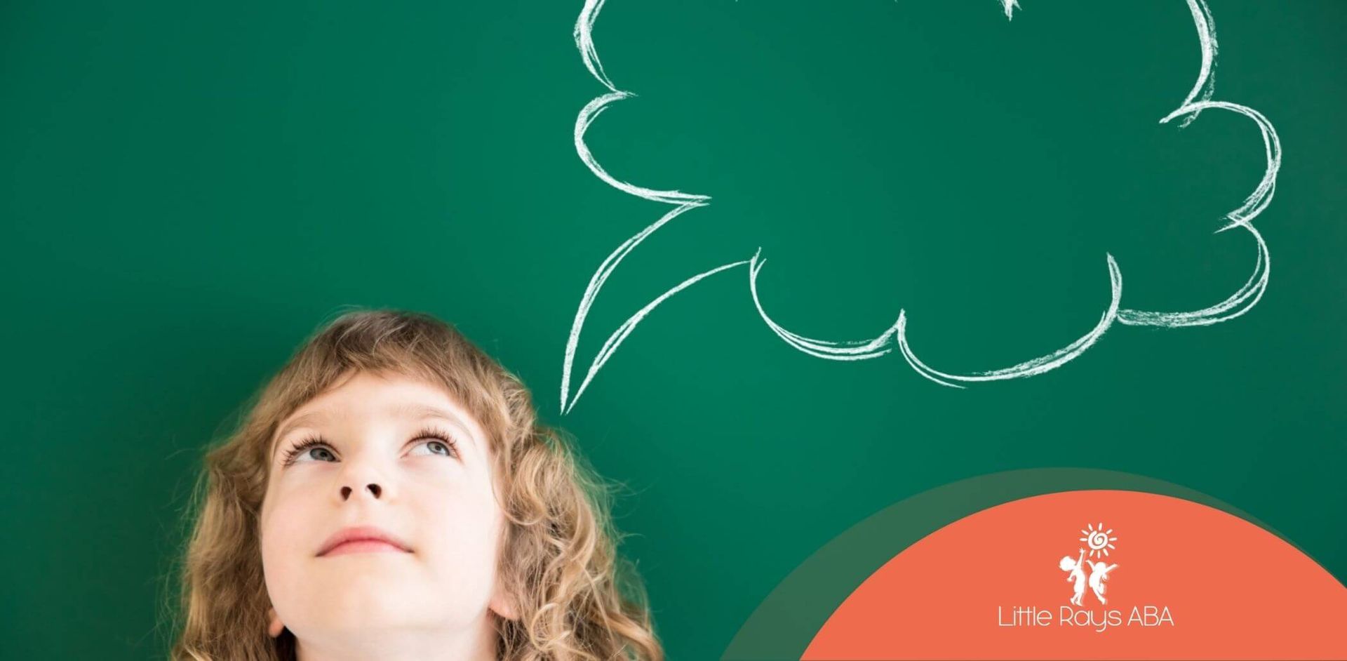 A child with autism looking up at a chalk-drawn thought bubble on a green chalkboard.