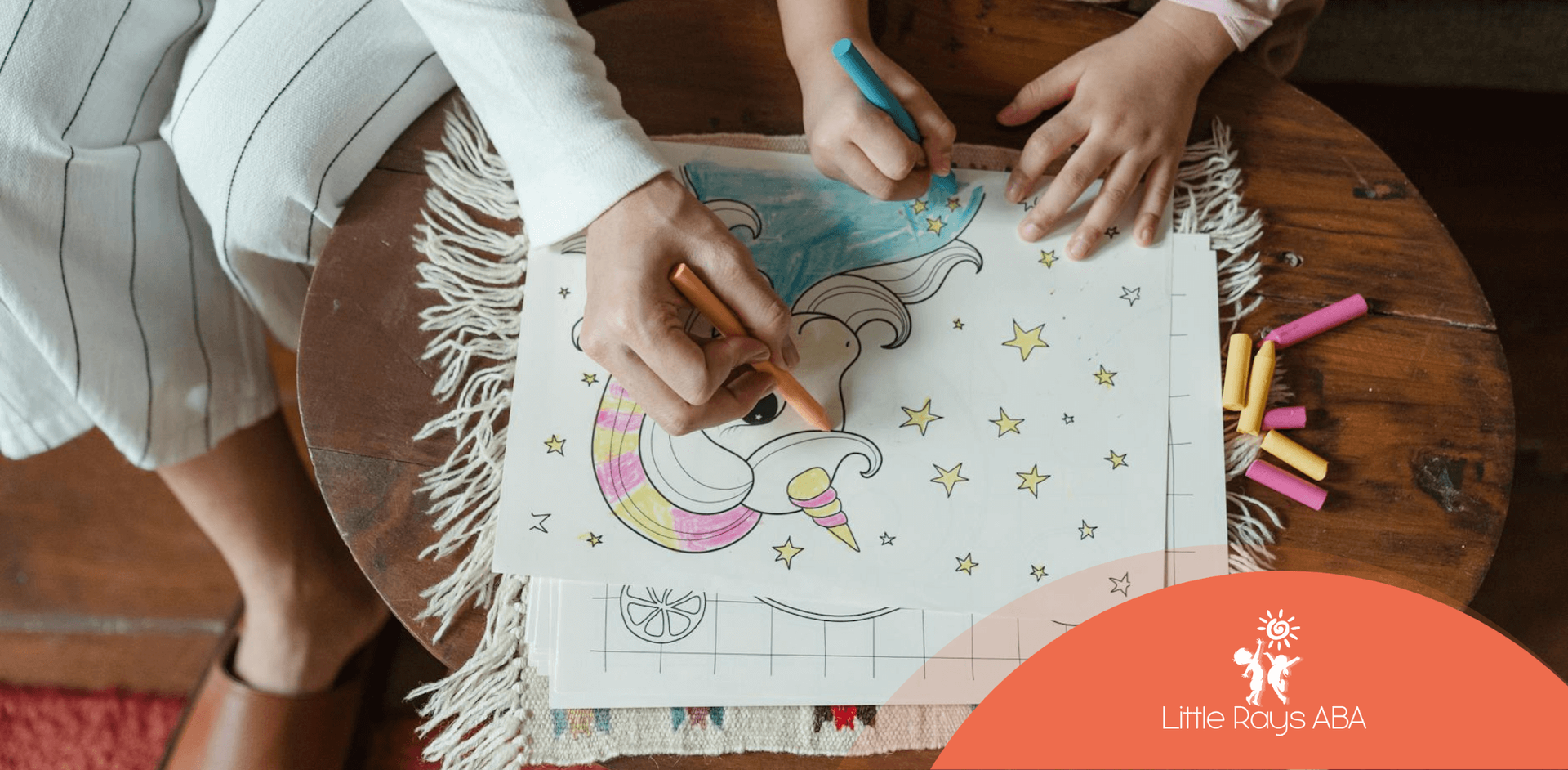 Autistic child and RBT coloring together with crayons on a unicorn drawing during ABA therapy in FL.