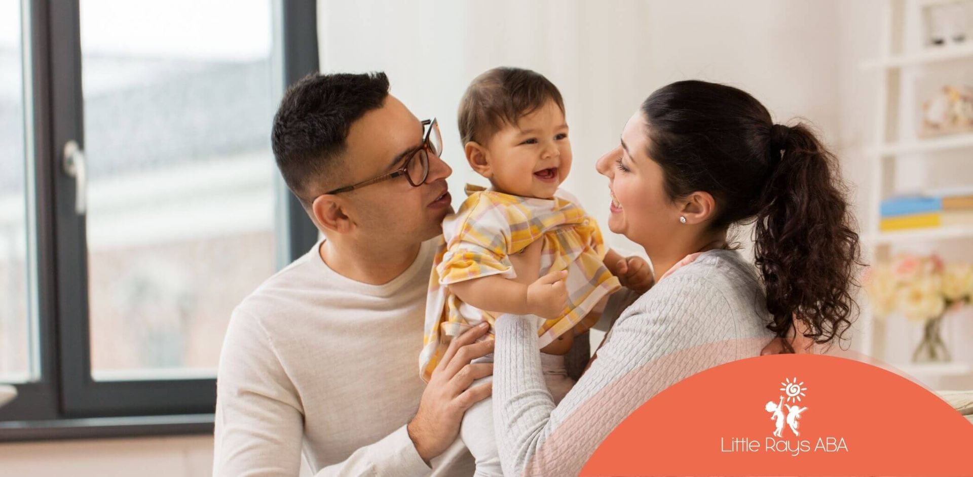 A man and woman are holding autistic baby in their arms.
