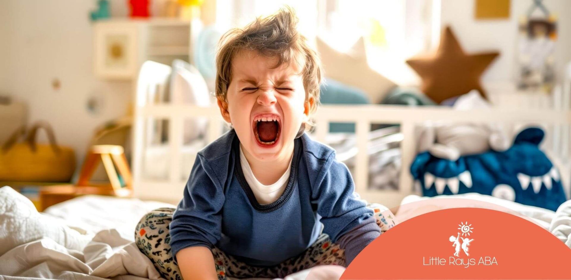 A young boy is sitting on a bed screaming.