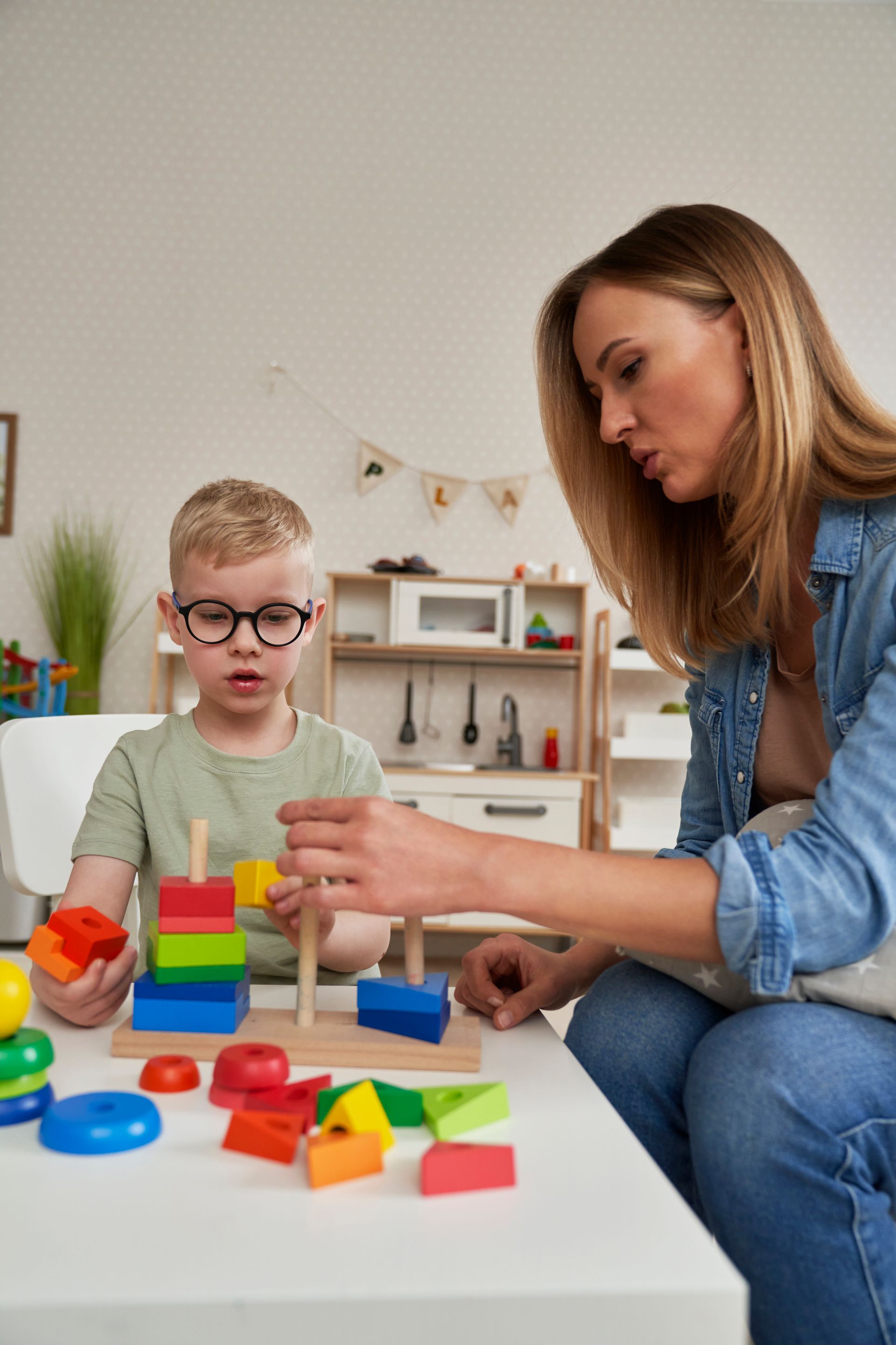 An RBT and a child are playing with blocks on the floor during an in-home aba therapy session