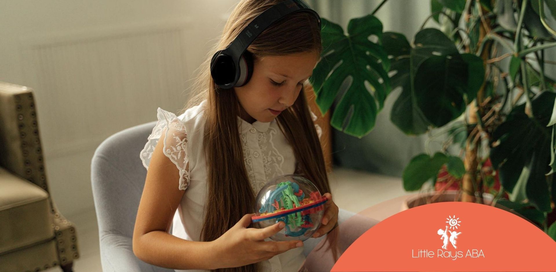 Autistic girl wearing a noise-canceling headphones playing with a colorful sensory toy in Florida.