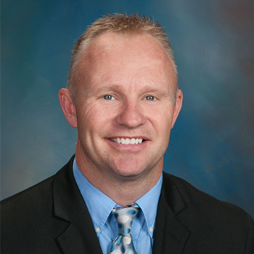 A man in a suit and tie is smiling for the camera.
