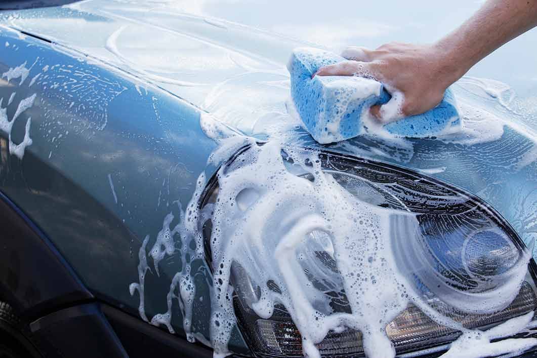 A Person Is Washing A Car With A Sponge And Soap - San Pablo, CA - Grand Prix Car Wash San Pablo