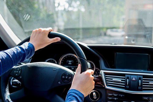 A Person Is Driving A Car With Their Hands On The Steering Wheel - San Pablo, CA - Grand Prix Car Wash San Pablo