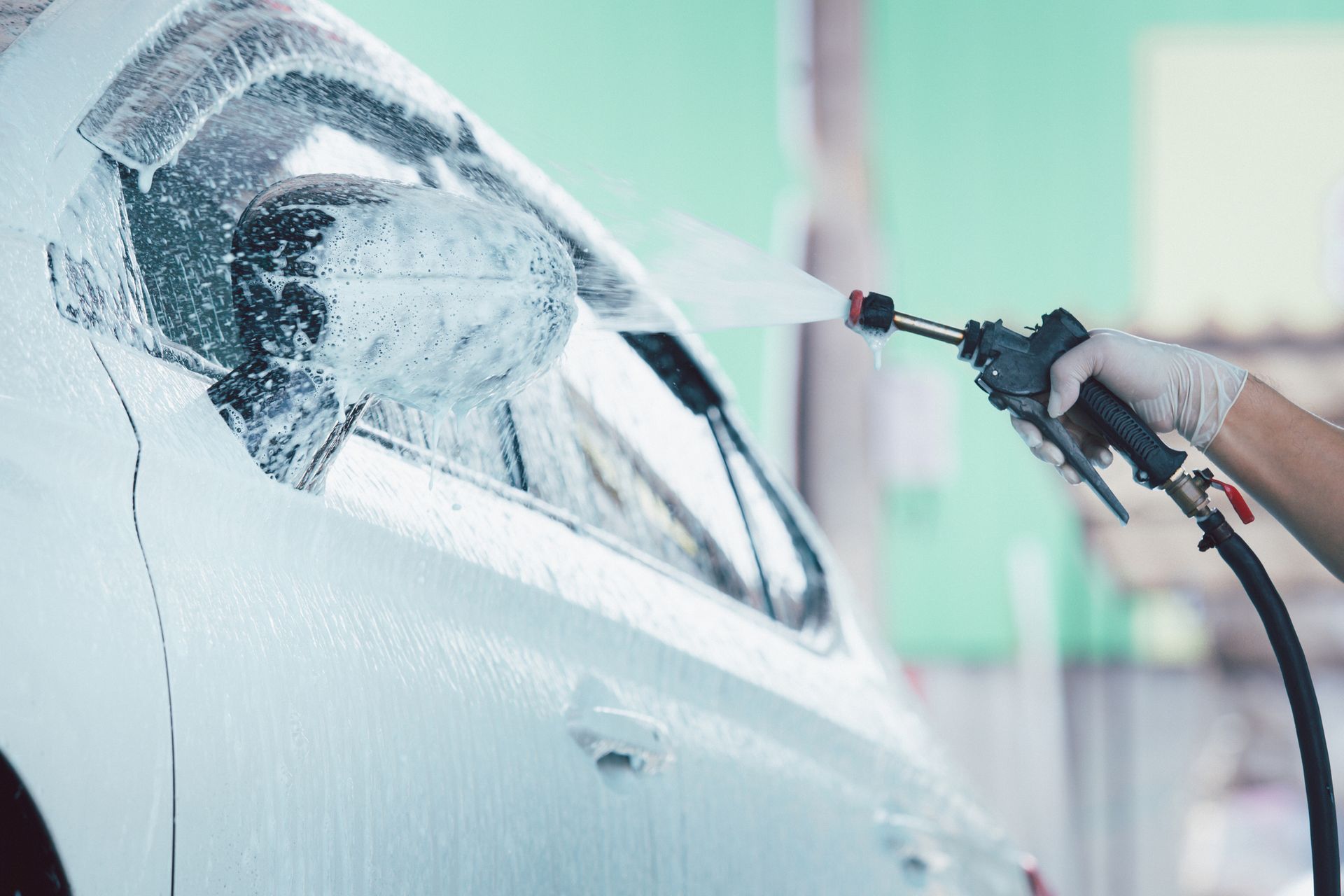 A Person Is Washing A Car With A High Pressure Washer - San Pablo, CA - Grand Prix Car Wash San Pablo