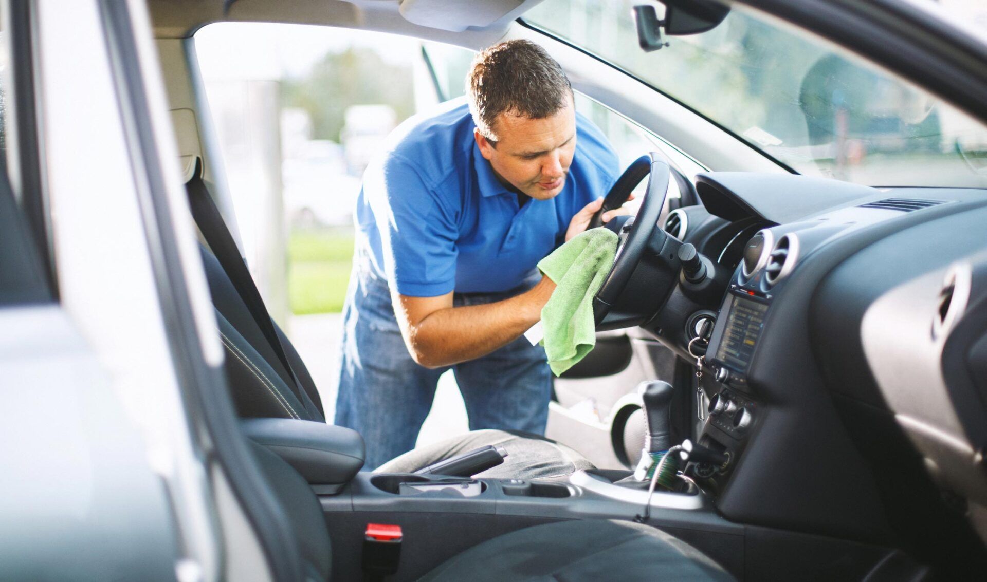 A Man Is Cleaning The Interior Of A Car With A Cloth - San Pablo, CA - Grand Prix Car Wash San Pablo