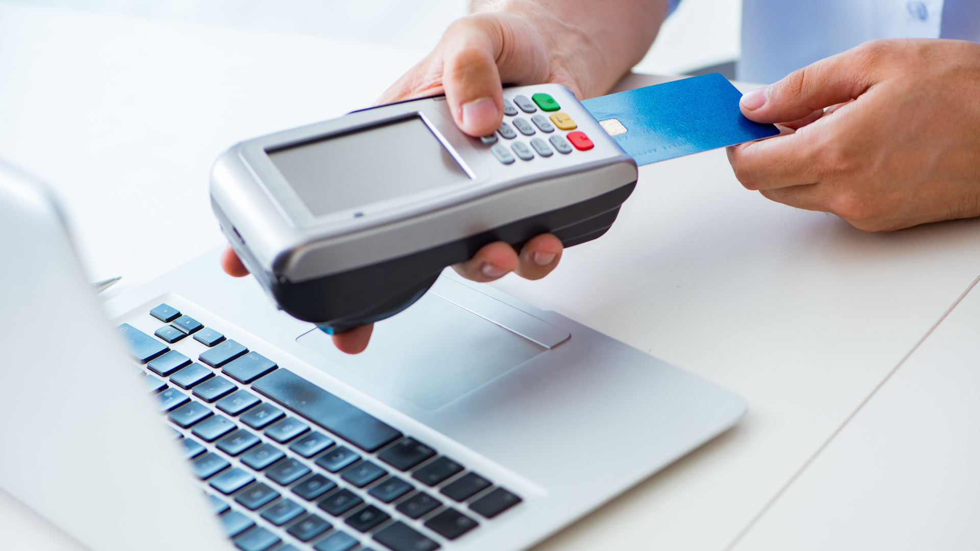 A person is using a credit card to pay for something on a laptop.