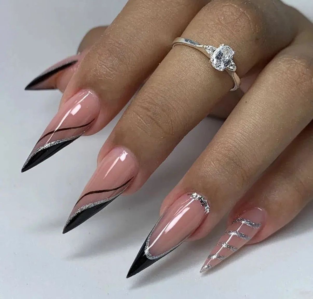 Close-up of manicured nails with a light blue and peach design featuring a floral pattern and netting detail.