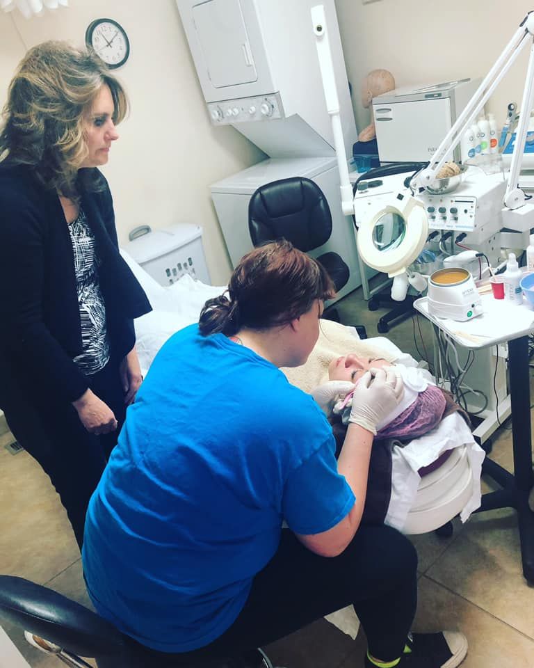 A woman in a blue shirt is working on a patient