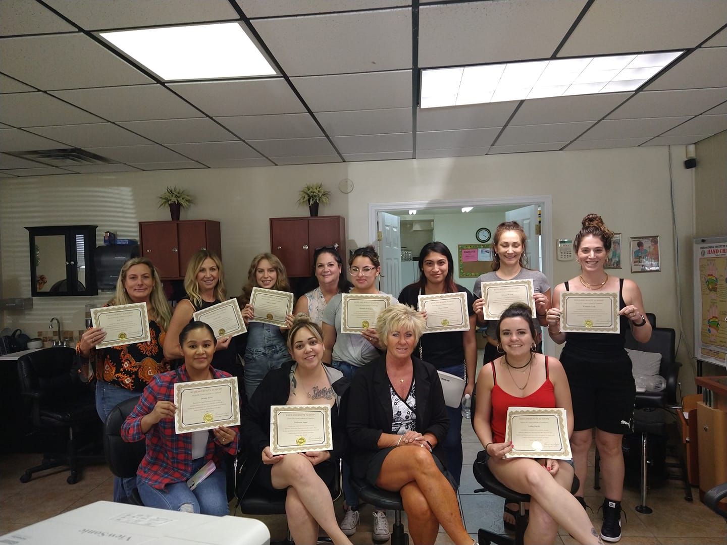 A group of women are sitting in a room holding certificates.