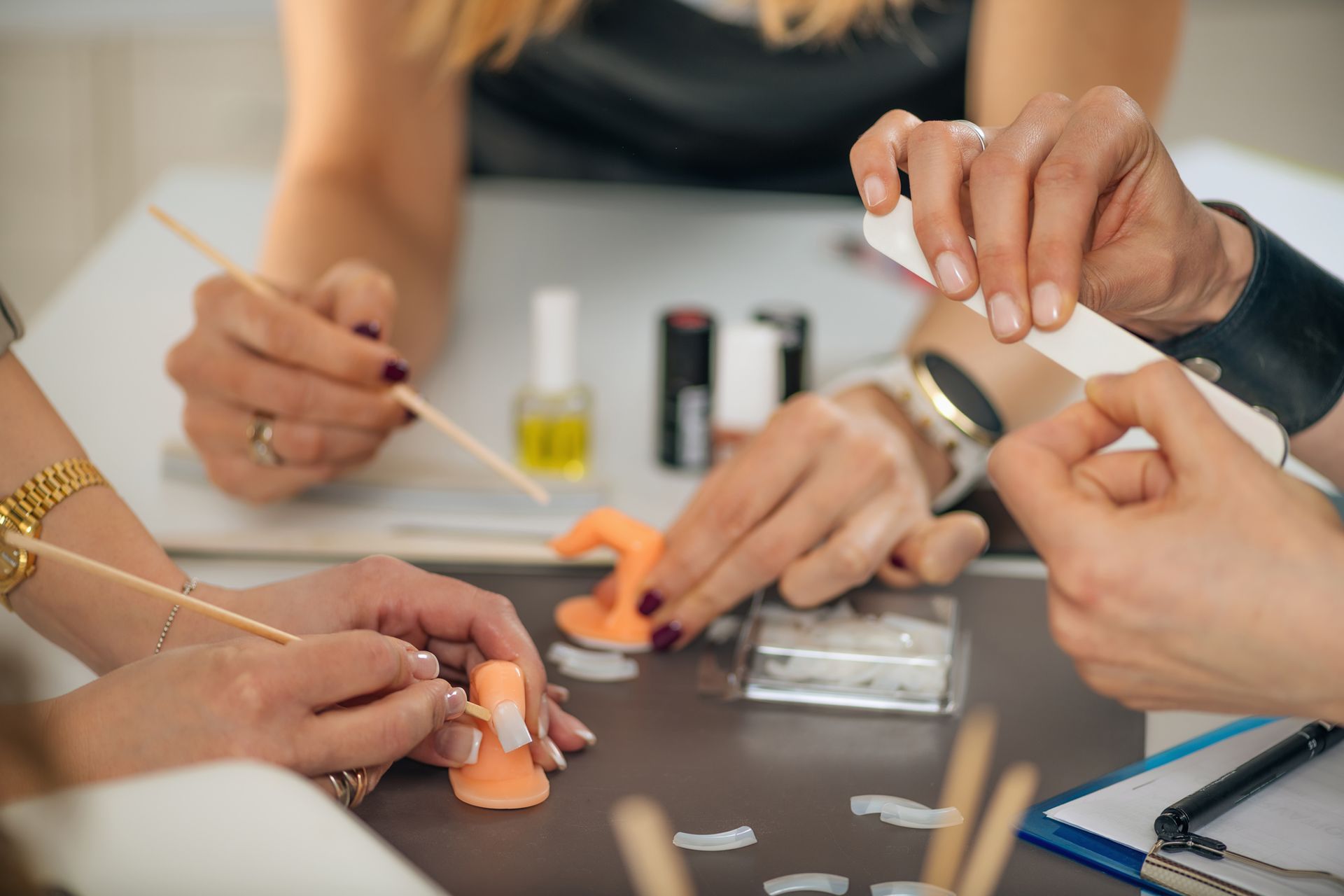 A group of people are sitting around a table getting their nails done.