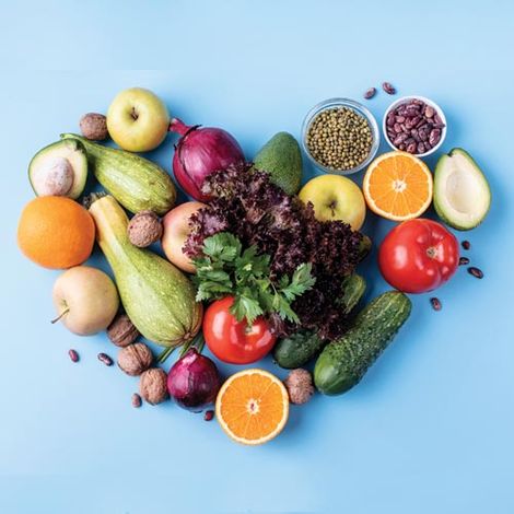 A heart made of fruits and vegetables on a blue background